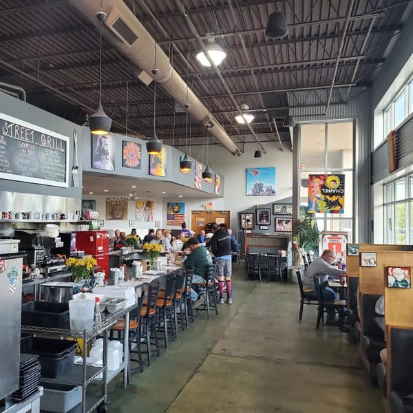 A bustling Green Street Grill diner interior with patrons seated at the counter and tables.