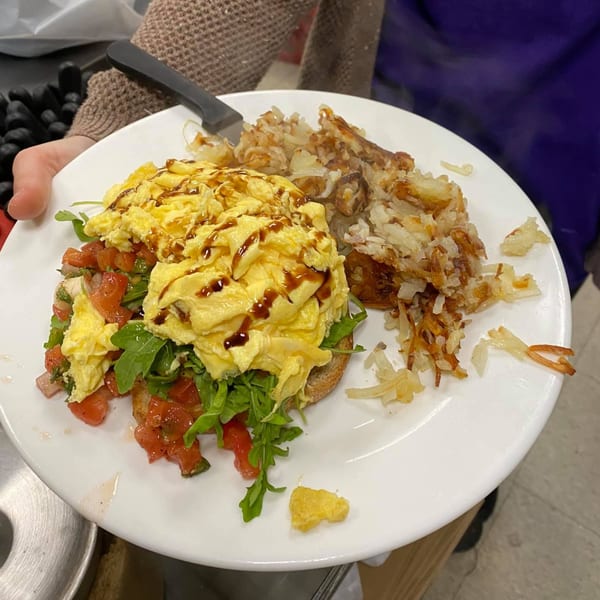 A Green Street Grill breakfast plate with scrambled eggs, bruschetta, and hash browns.