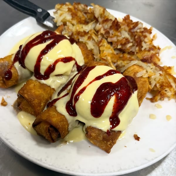 Green Street Grill's breakfast egg rolls topped with hollandaise and strawberry sauce, served with hash browns.